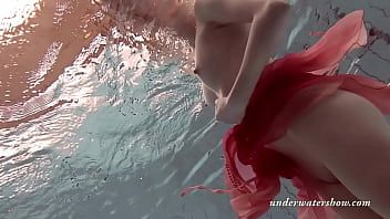 On the edge of a swimming pool you find a redheaded milf massaging her pussy